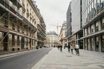 Rue d'un quartier en rénovation urbaine avec immeubles haussmanniens et façades modernes en verre, symbolisant la mutation immobilière